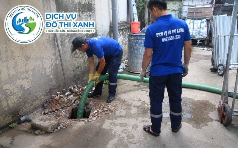 Nhân viên kéo ống hút hầm cầu qua cầu nhỏ tại khu vực xã Hiệp Hưng