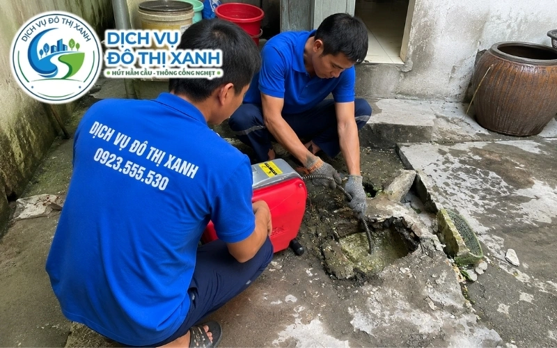 Nhân viên nạo bùn sông và cặn thực phẩm trong cống khu chợ ven sông Trà Ôn