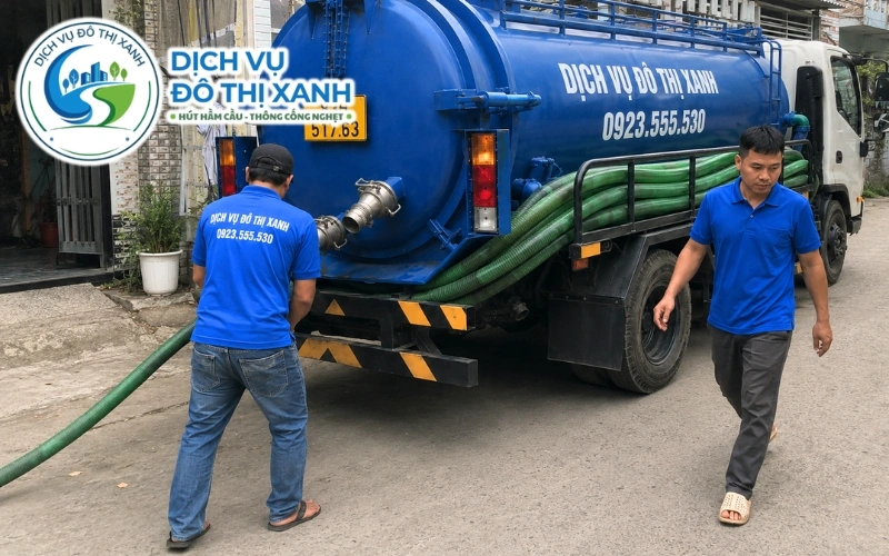 Nhân viên Đô Thị Xanh dùng xe nhỏ và kéo ống hút hầm cầu vào vườn cây tại Kế Sách