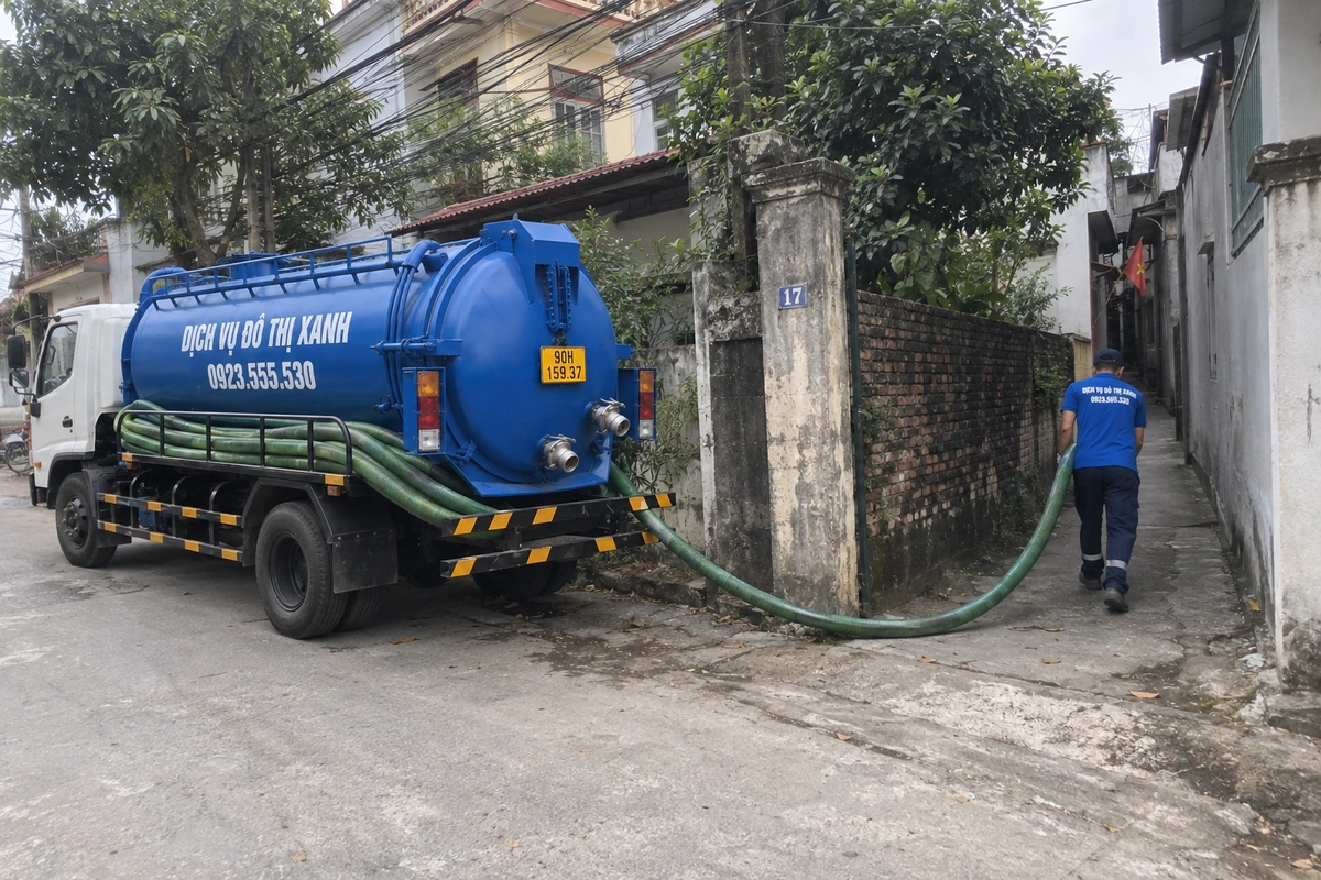 Nhân viên kéo ống hút bể phốt qua ngõ