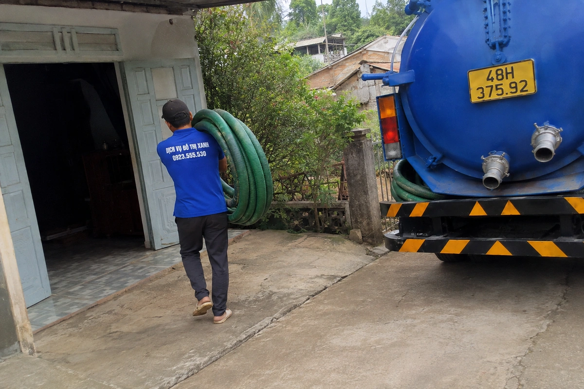 Nhân viên mang cuộn ống hút bên xe